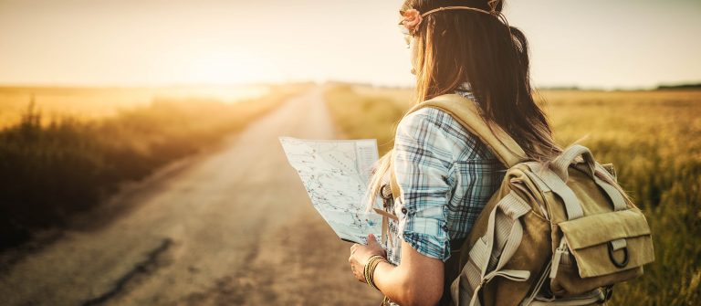 Attractive backpacker girl looking map
