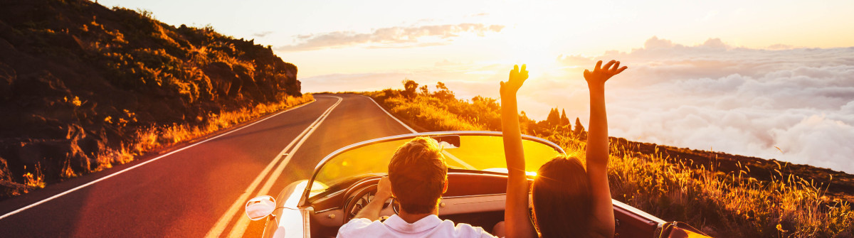 happy-couple-driving-on-country-road-into-the-sunset-in-classic-vintage-sports-car-shutterstock_305567459-2-1200×335