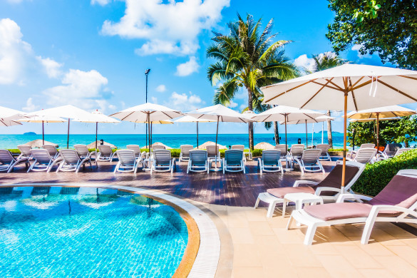 beautiful-luxury-umbrella-and-chair-around-outdoor-swimming-pool-in-hotel-resort-shutterstock_420110824-2-585x390