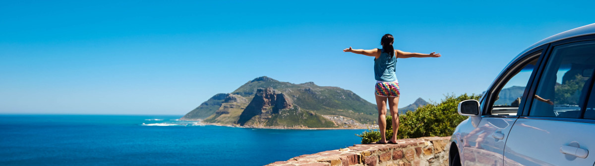 carefree-tourist-stands-on-chapmans-peak-drive-shutterstock_126991940-2-1200×335
