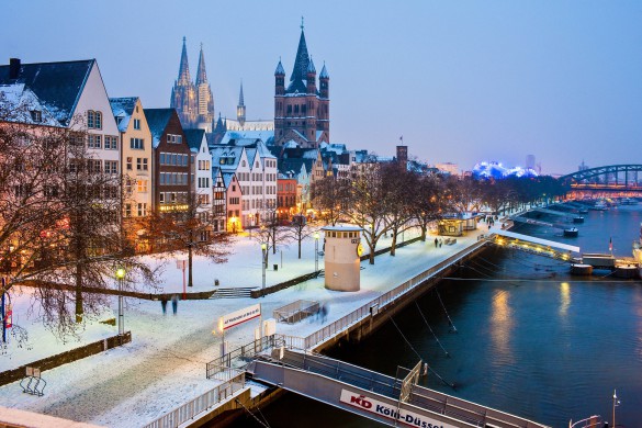Cologne, Germany - February 14, 2010. Cologne's Old Town in winter time. View from the Deutz bridge. The pedestrian promenade with the cruise ship jetties in front. In the background the church Great Saint Martin (Groß St. Martin) and the Cologne Cathedral.