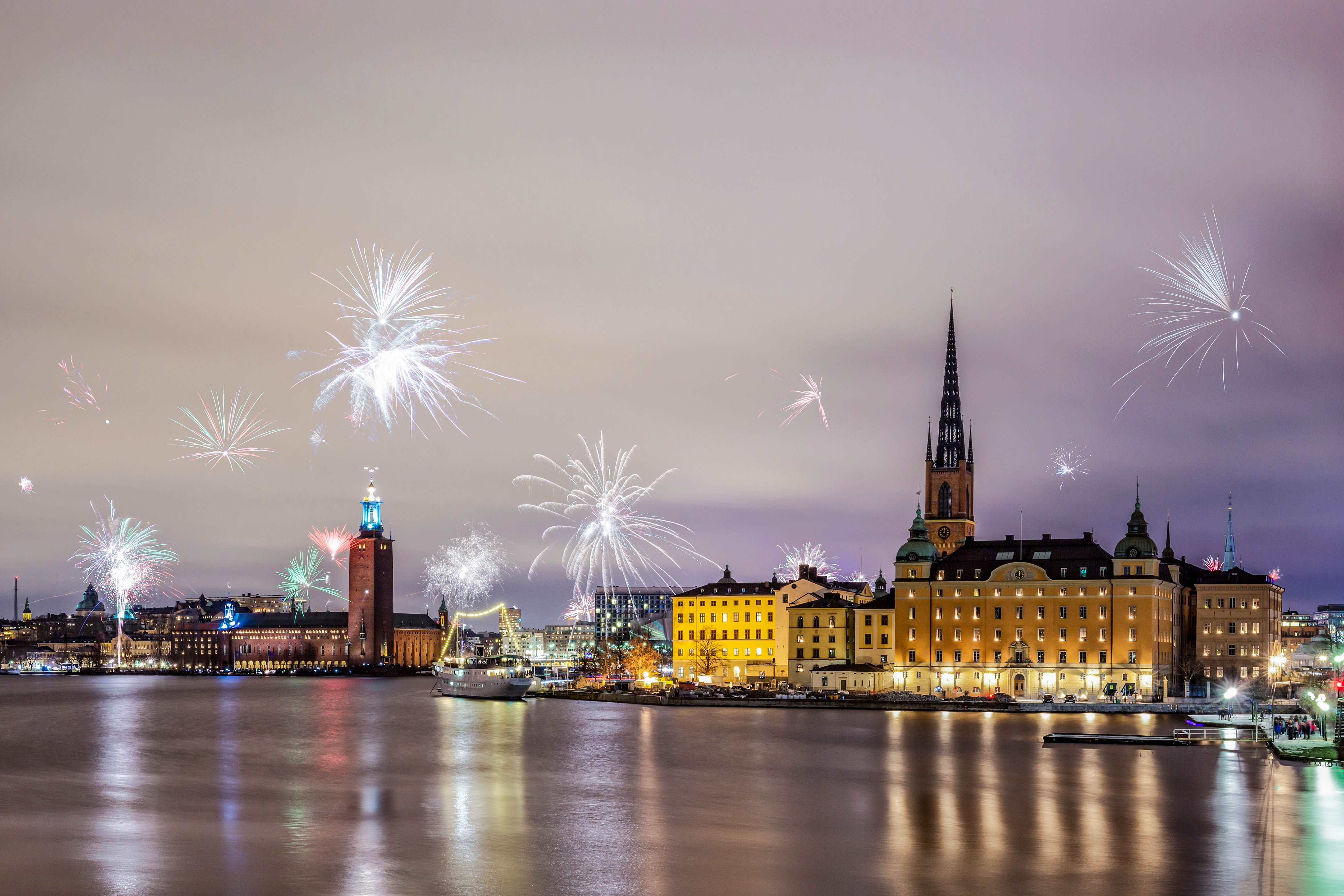 Stockholm, Sweden – Jan 1, 2016: New Year Fireworks are popping across Stockholm main islands and city hall on Jan 1 in Stockholm. On New Year's Eve, Stockholm's streets are filled with families, friends and lovers with fireworks and champagne in their hands.