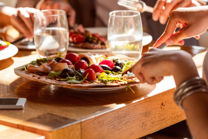 Frau isst eine Pizza in einem Restaurant