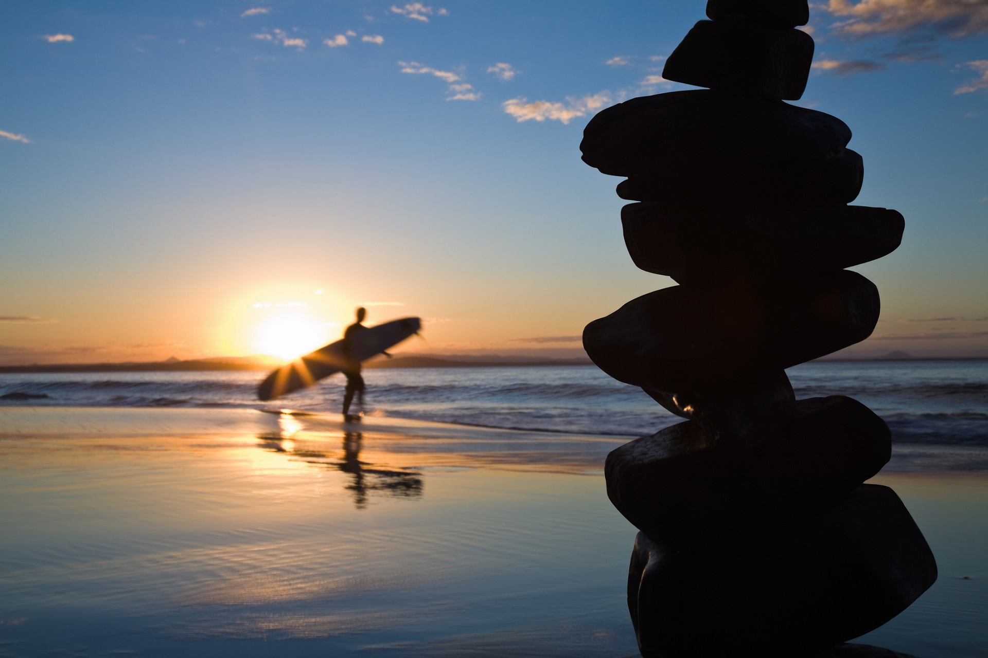 ein Surfer am Strand während des Sonnenuntergangs