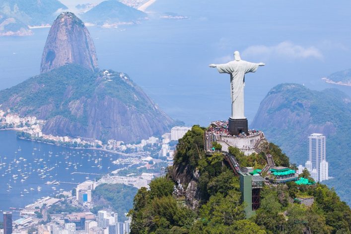 Luftaufnahme von Rio de Janeiro mit dem Weltwunder der Neuzeit, der Christusstatue auf dem Corcovado, vor der Küstenlinie und dem Zuckerhut.