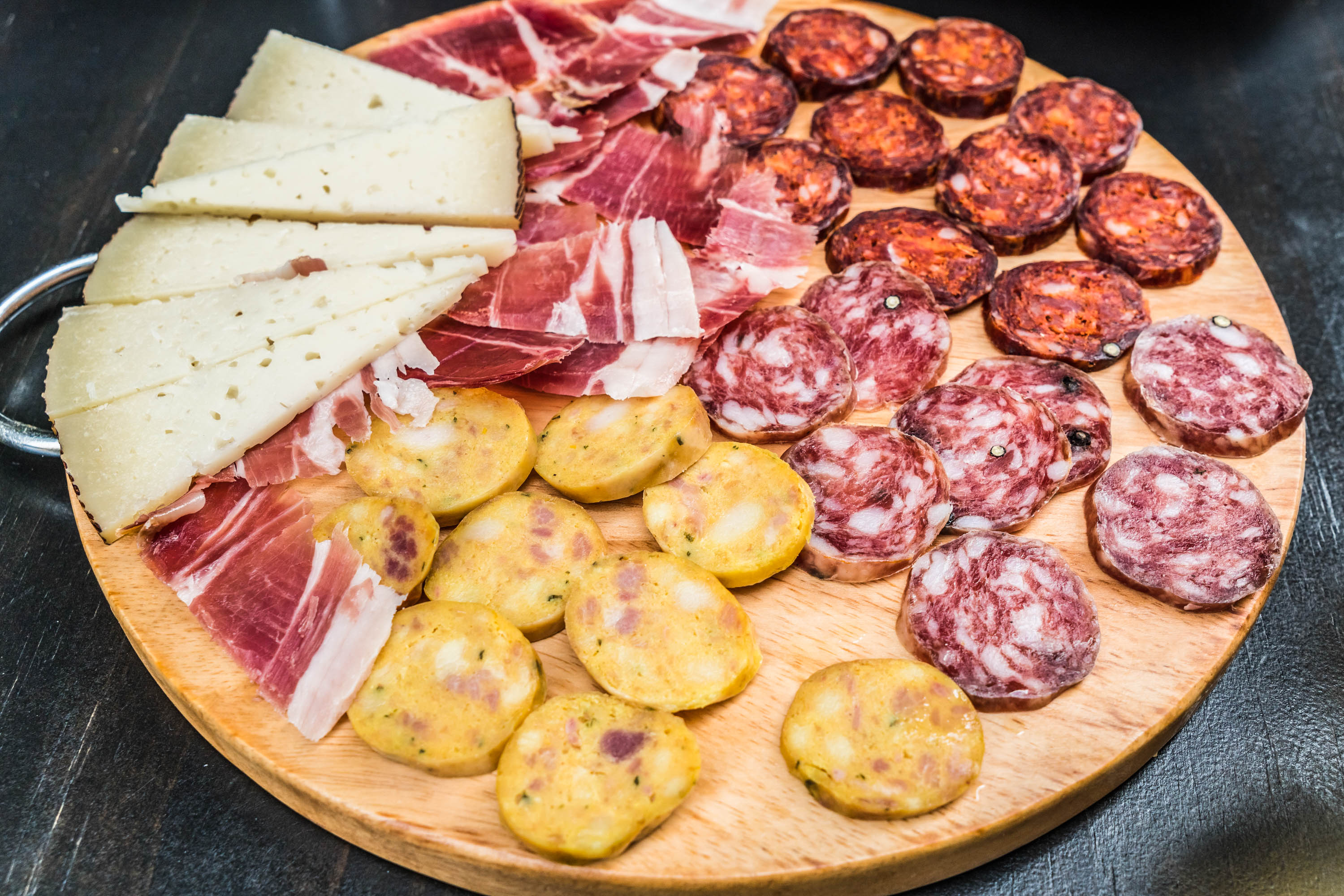 Typical cured ham, sausage and cheese plate tapa in Granada, Andalusia, Spain.