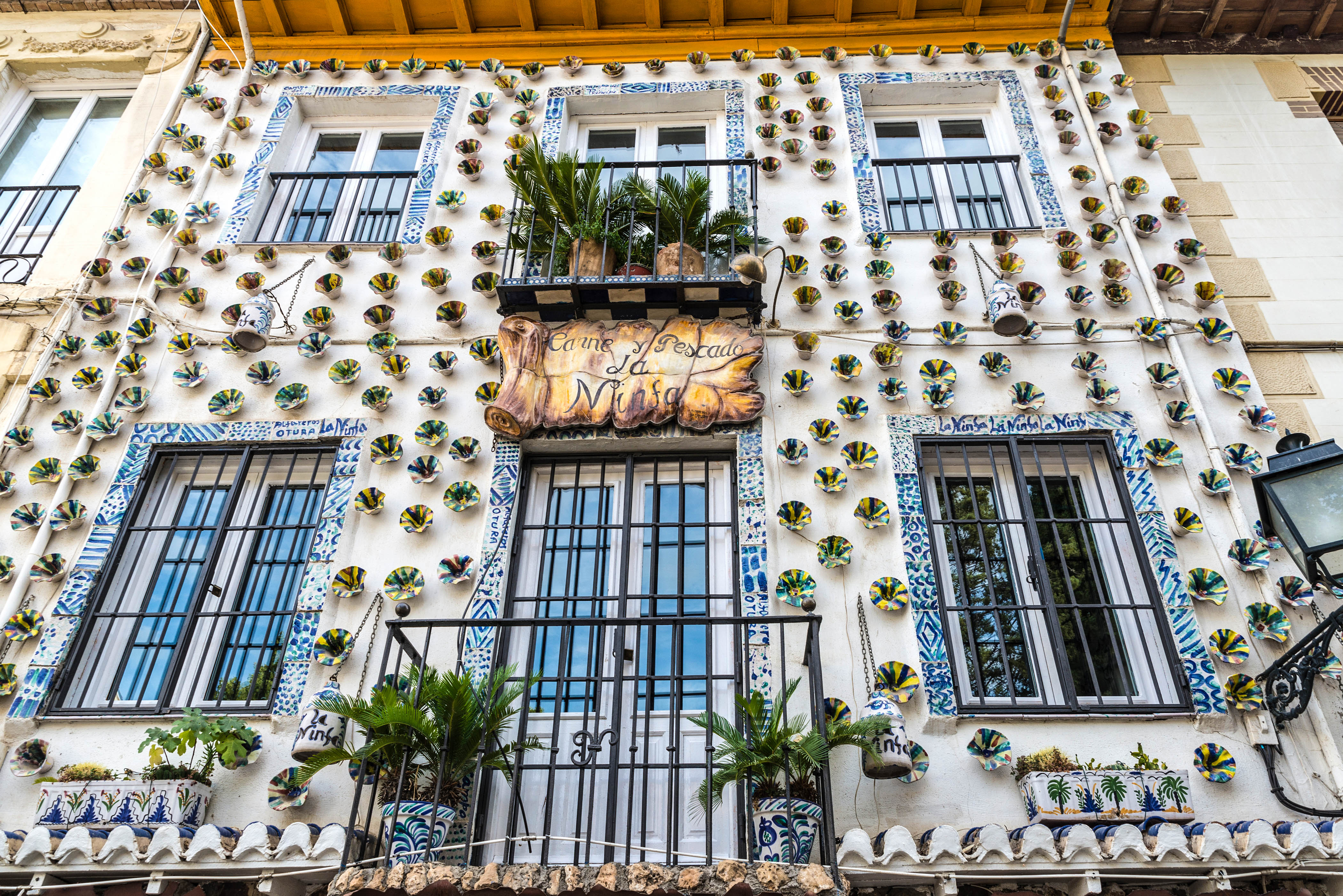 Granada, Spain - August 10, 2015: Facade of a restaurant decorated with painted vases in the old town of Granada, Andalusia, Spain.