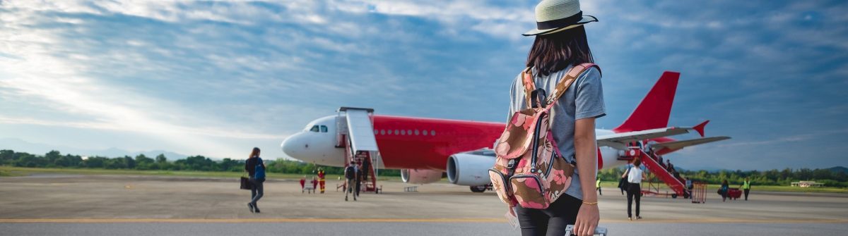 Girl traveler with luggage going to plane
