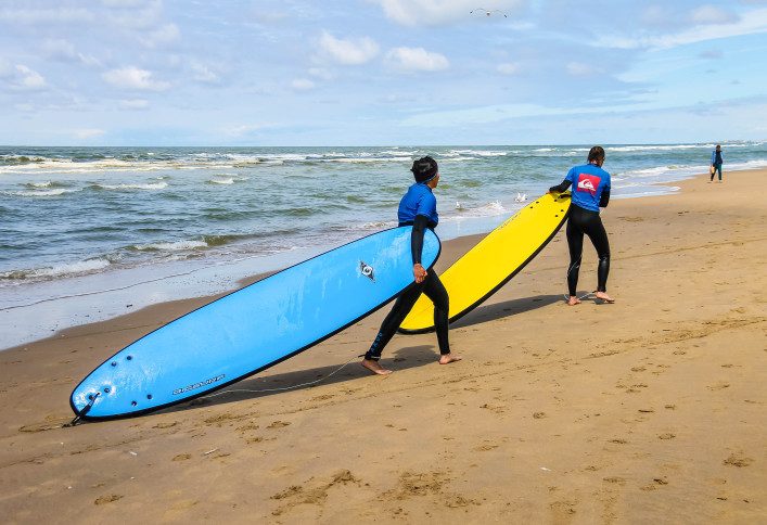 young-surfer-friends-walking-along-the-shore-carrying-their-surfing-boards-shutterstock_335484626-editorial-only-nick_nick-2
