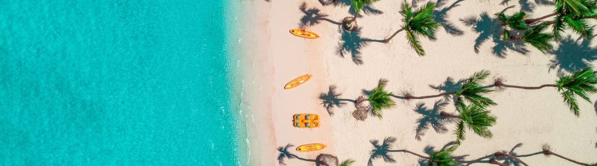 Bavaro Beach in der Dominikanischen Republik: Karibischer Strandurlaub mit türkisblauem Meer, weißem Sand, Sonnenliegen und Palmen von oben fotografiert.