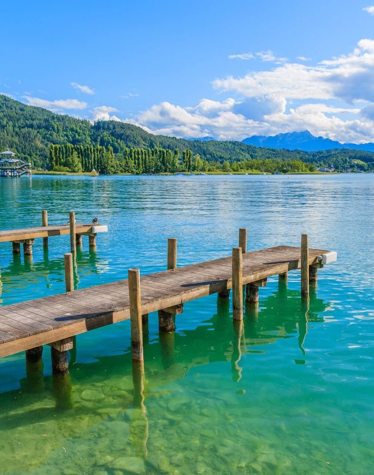 Wooden-pier-for-mooring-boats-on-Worthersee-lake-on-beautiful-summer-day-Austria-shutterstock_294768299