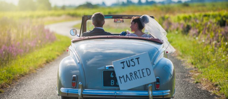 newlywed-couple-driving-convertible-retro-car_shutterstock_261887495