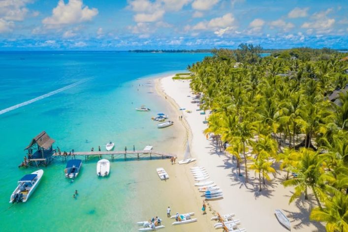 Luftaufnahme des wunderschönen Strandes Trou auch Biches auf Mauritius. Ein schneeweißer Strand mit vielen Plamen und einem türkisblauen Meer.