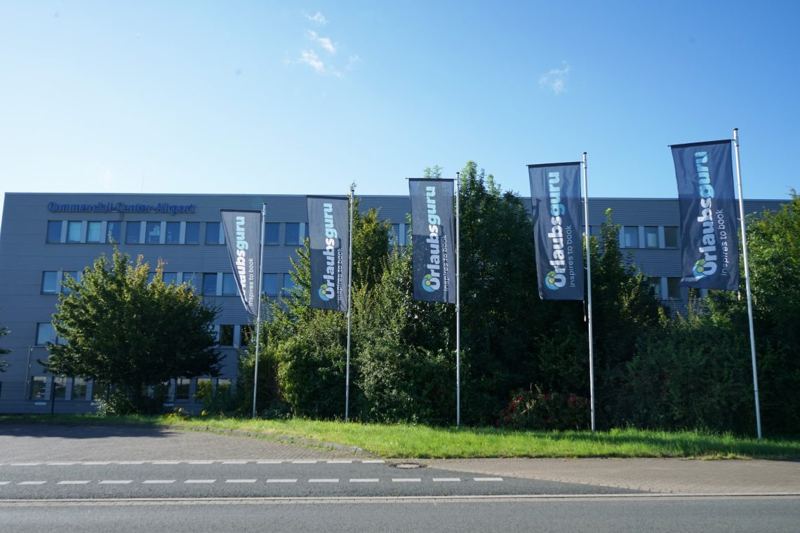 Bürogebäude mit Urlaubsguru-Fahnen davor
